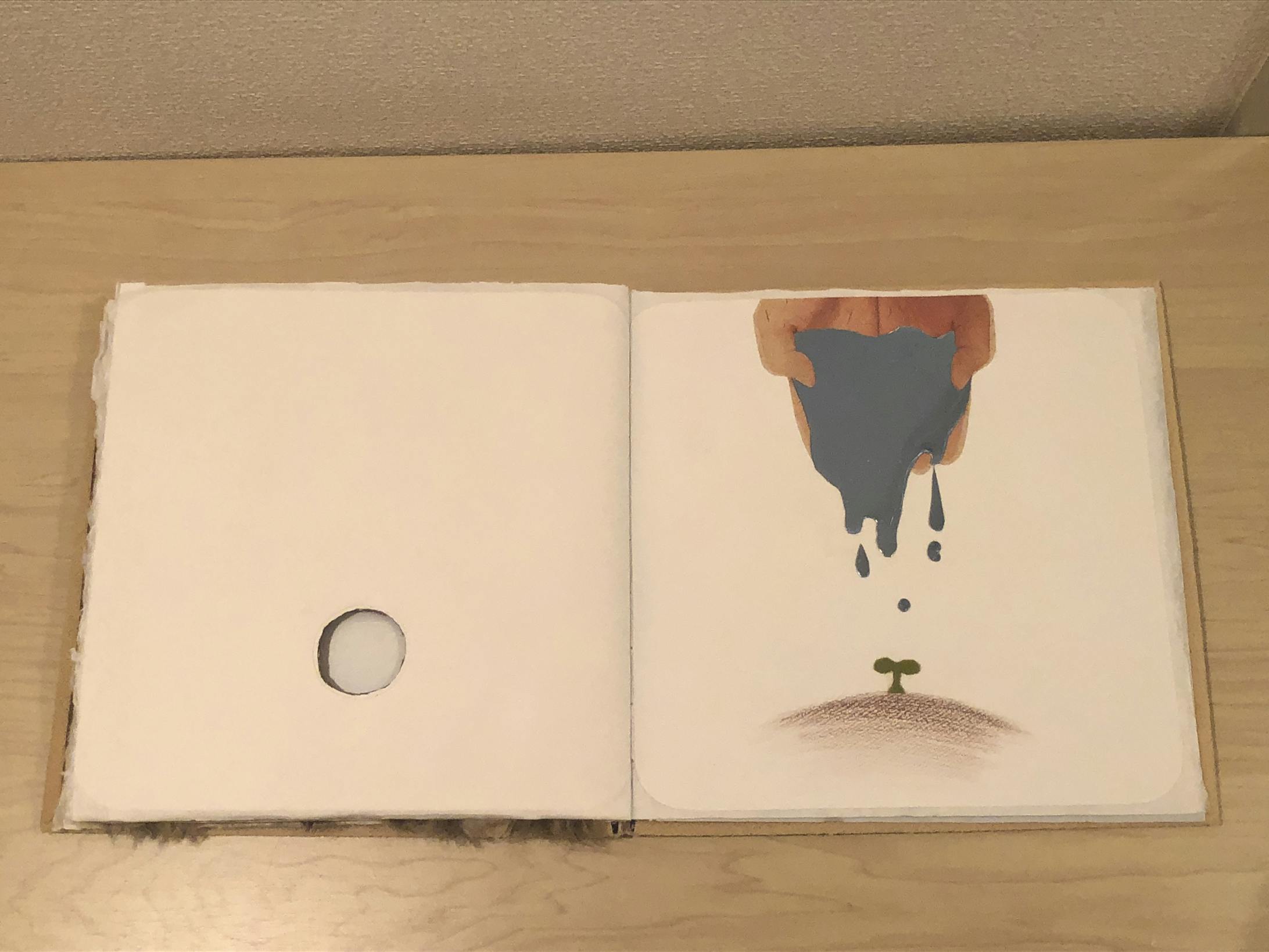 このページは、色鉛筆やフェルト、鏡面シートを使用。前ページの木の洞からこのページの新芽が見えるように、配置や色味に注意を払いました。また、優しい風合いを醸し出せるように、手の写真はクラフト紙に印刷するなど、こだわりを持って取り組みました。 このページは、色鉛筆やフェルト、鏡面シートを使用。前ページの木の洞からこのページの新芽が見えるように、配置や色味に注意を払いました。また、優しい風合いを醸し出せるように、手の写真はクラフト紙に印刷するなど、こだわりを持って取り組みました。