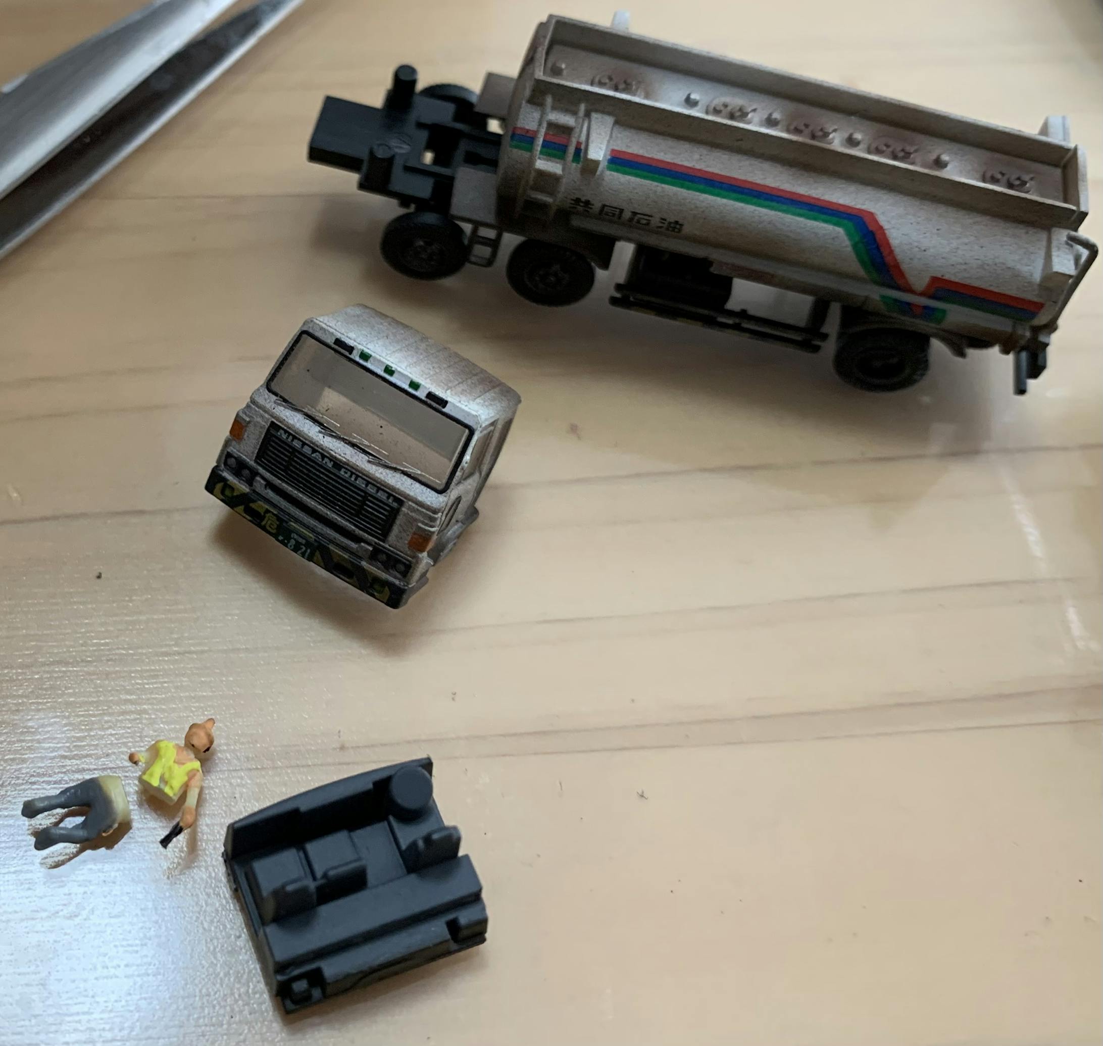 続いてタンク車に人を乗せてみます。工場作業員に見えるよう黄色のベストを着せました。このままだと乗らないので、下半身をカットしていきます。