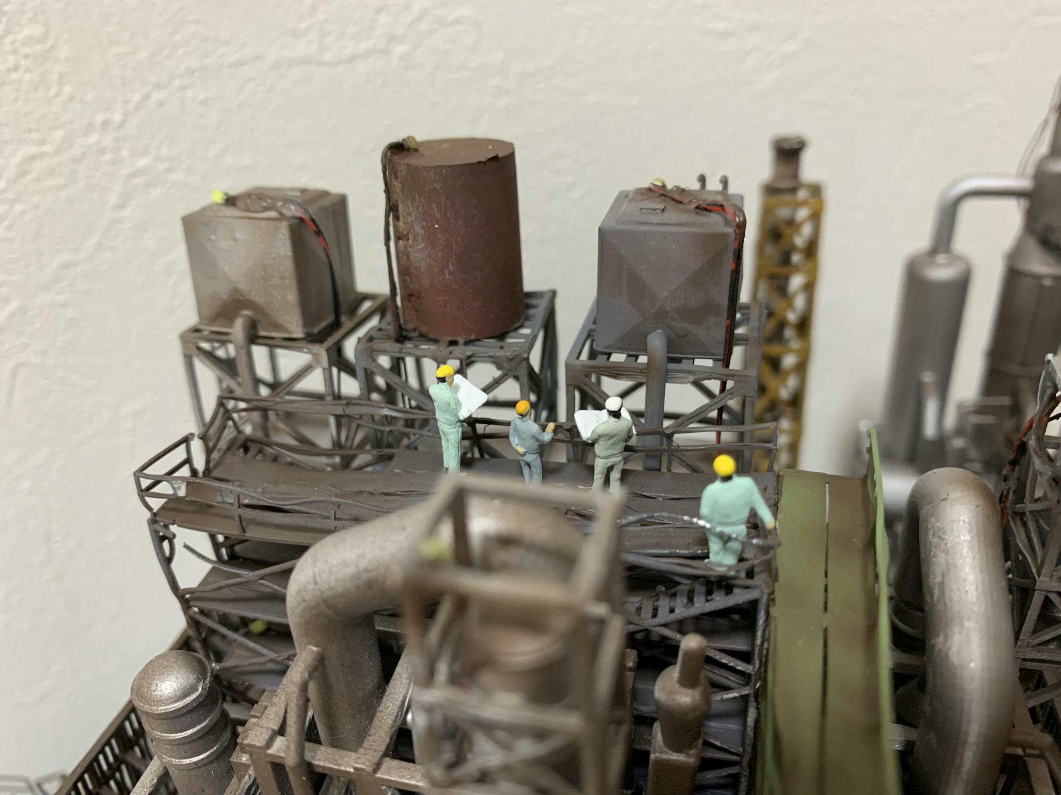 工場建屋の屋上では、作業員が工場設備について説明しています。後ろで手すりに寄りかかりながら偉そうに話を聞いている人もいます。 工場建屋の屋上では、作業員が工場設備について説明しています。後ろで手すりに寄りかかりながら偉そうに話を聞いている人もいます。